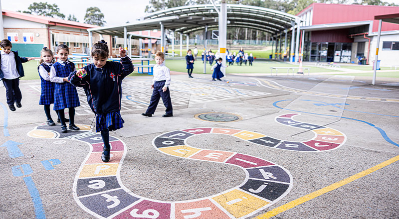 Student hopping on hop scotch in the playground at Bethany Catholic Primary School Glenmore Park