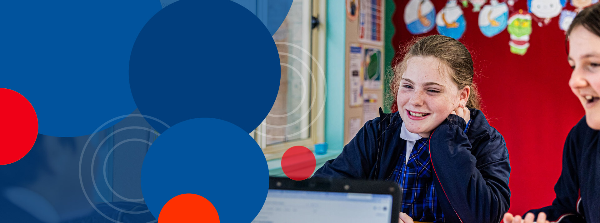 Student smiling in front of laptop at Bethany Catholic Primary School Glenmore Park